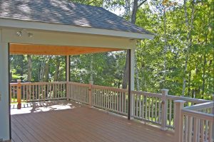 deck with white wood material in backyard with many trees.