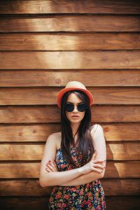 beautiful girl in sunglasses posing for the camera on brown background